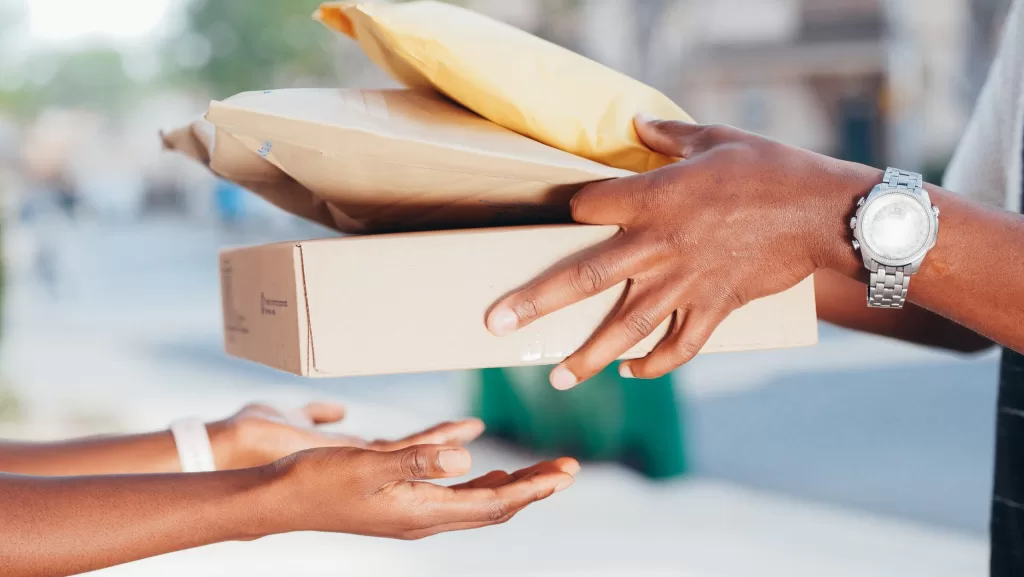 Image of a person delivering a package to a customer to denote last mile delivery