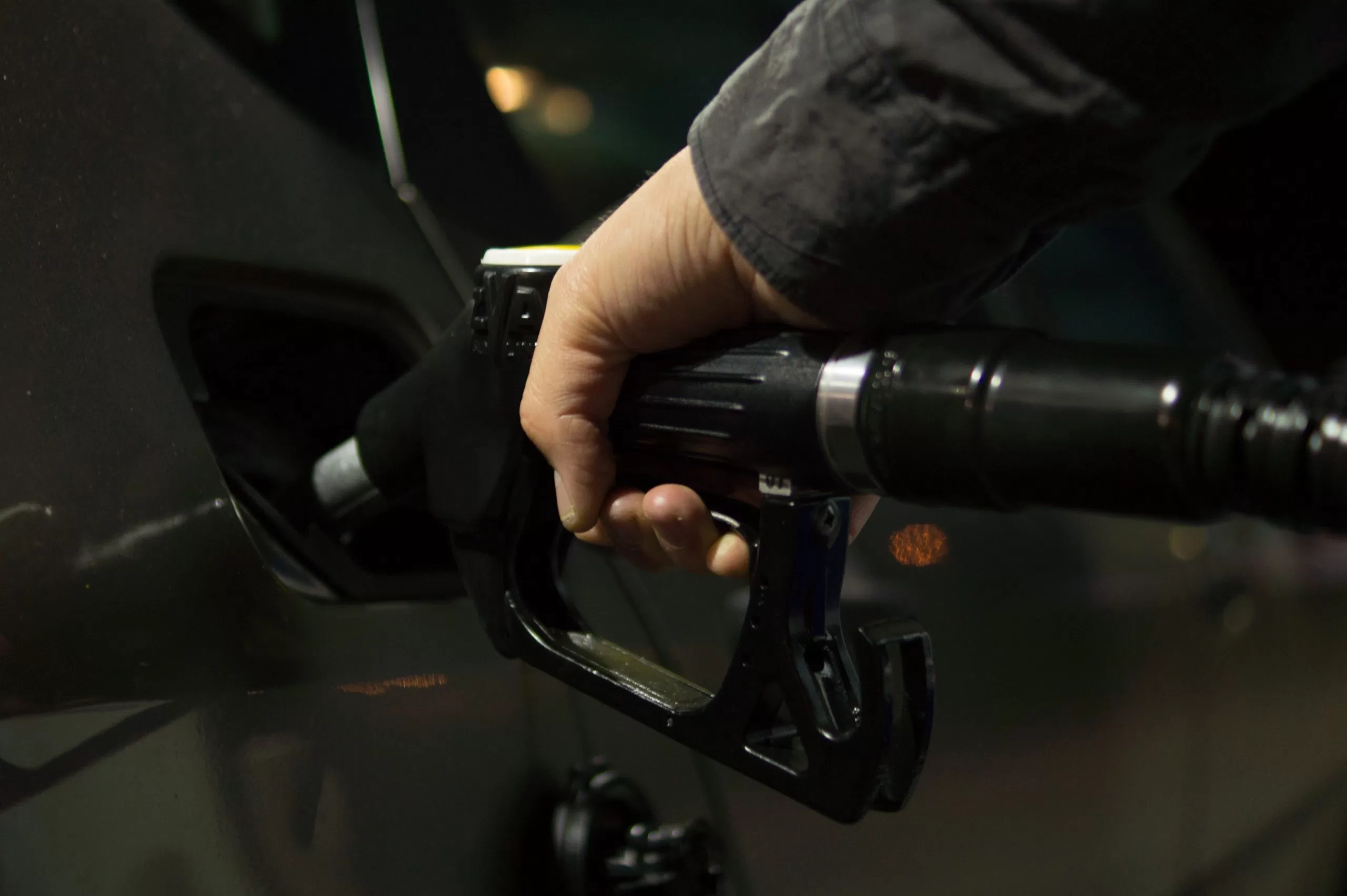 Image of a person filling fuel in a vehicle to denote the need to improve fleet fuel efficiency