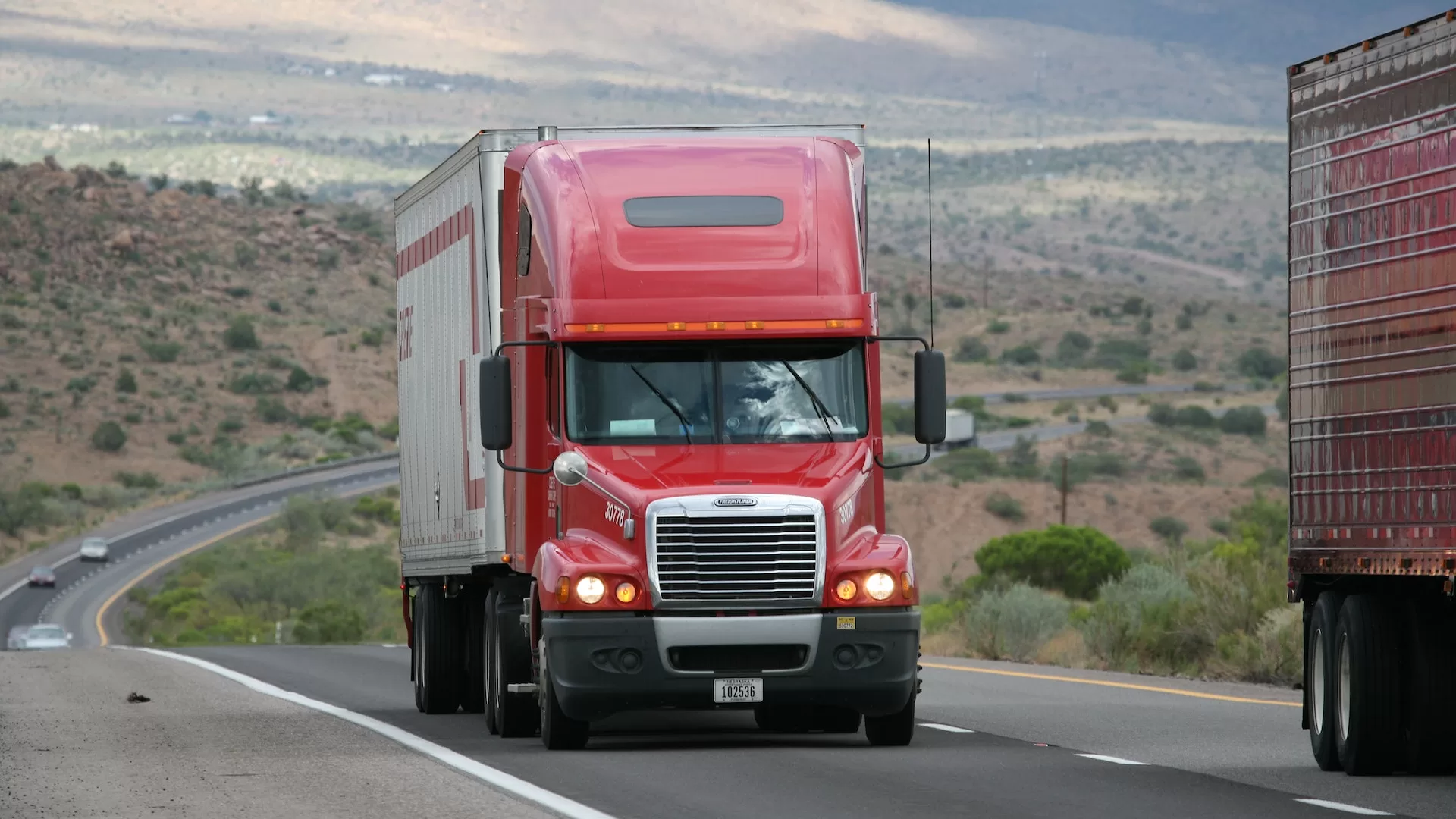 Image of a red colour truck on a toll lane to represent FASTag payment issues