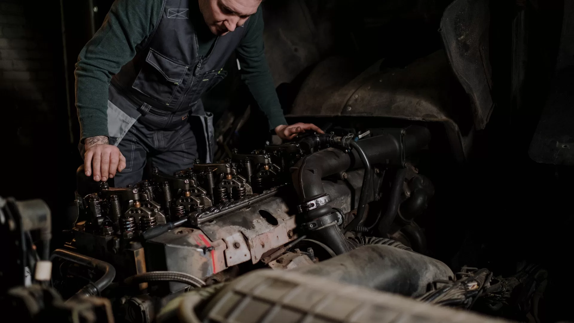 Image of a person repairing a truck engine to denote truck engine spare parts