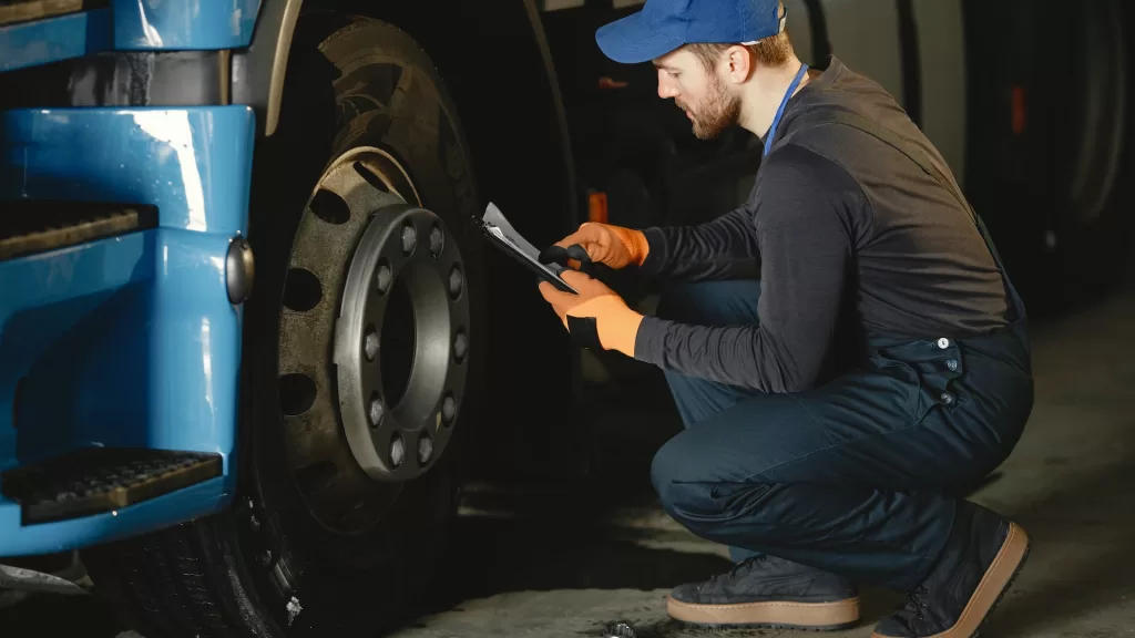 Image of a person inspecting a truck tire to denote commercial truck tires
