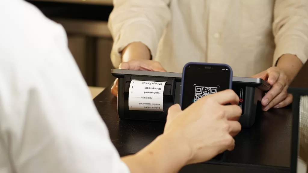 Image of a person making scanning a QR code to denote fintech solutions